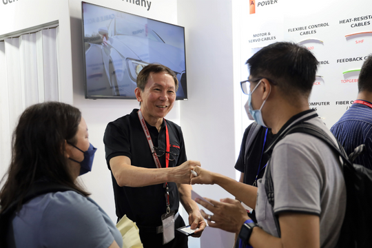 Mr. Sam, Manager at Helukabel Singapore Pte Ltd, is having an in-depth conversation with customers at the exhibition.